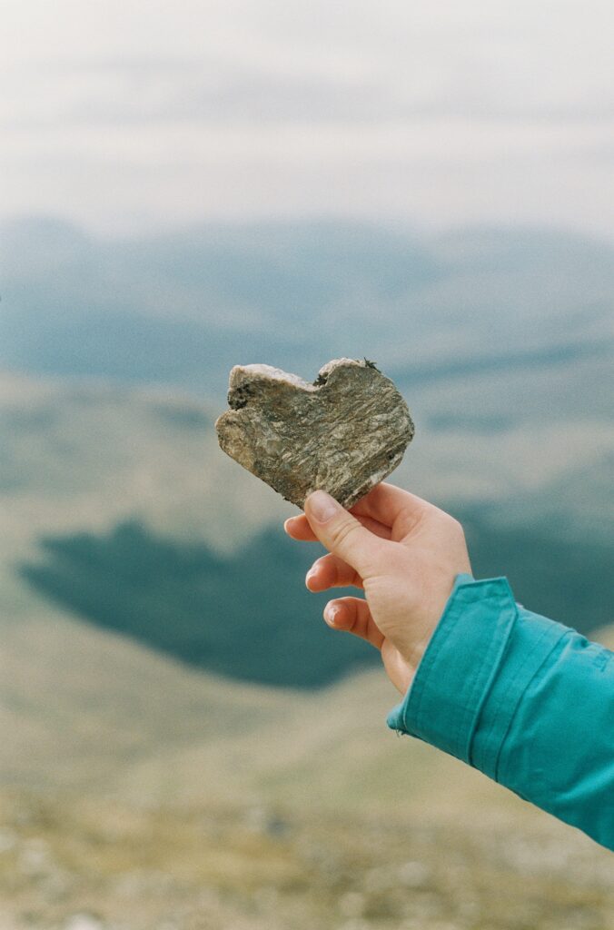 Symbole du Cœur sur une roche porte par une main 