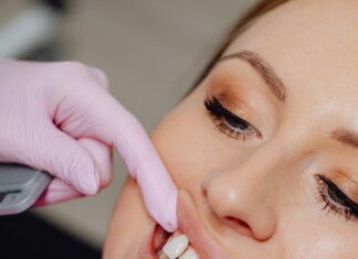 Une femme assise sur le fauteuil d'un cabinet dentaire, le visage empreint d'une sérénité renouvelée, alors que le dentiste s'apprête à réparer une dent cassée, symbolisant le processus de guérison et de renouvellement.