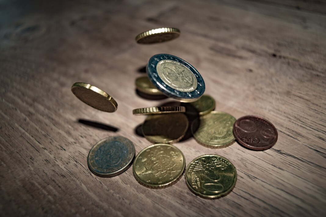 Pièce de monnaie étincelante sur le trottoir, symbole de chance et de mystère, illustrant la signification de l'argent trouvé par terre dans l'article sur la spiritualité